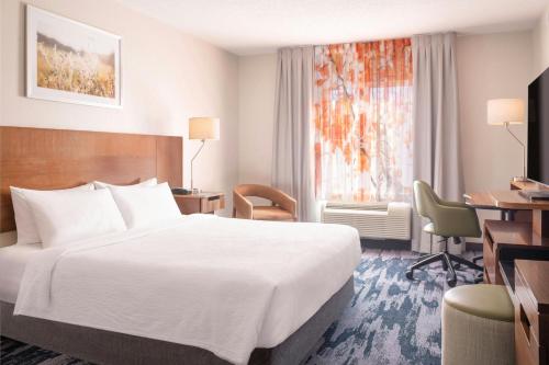 a hotel room with a bed and a desk and a window at Fairfield Inn & Suites by Marriott Cape Cod Hyannis in Hyannis