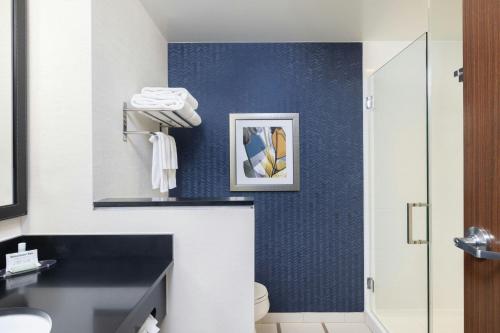 a bathroom with a toilet and a blue wall at Fairfield Inn & Suites by Marriott Cape Cod Hyannis in Hyannis