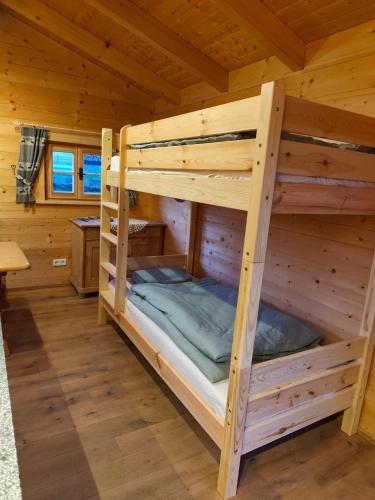 a bedroom with two bunk beds in a cabin at Blockhütte bei den Hühnchen in Rötz