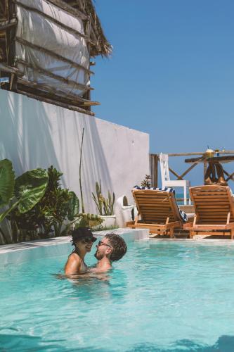 two people are sitting in a swimming pool at ZAN Ocean View Hotel in Jambiani