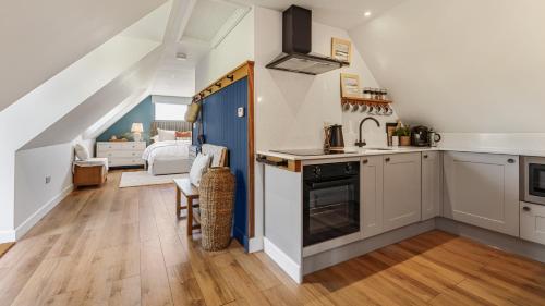 a kitchen with white cabinets and a blue door at Ferny Retreat in Bromyard