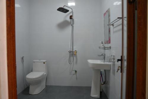 a bathroom with a shower and a toilet and a sink at Loop Tribe Hostel in Ha Giang