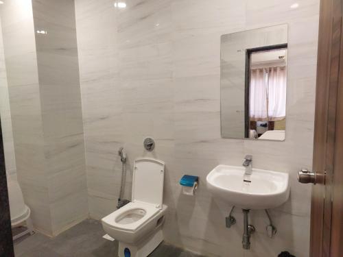 a bathroom with a toilet and a sink at Sunny's World Resort in Pune
