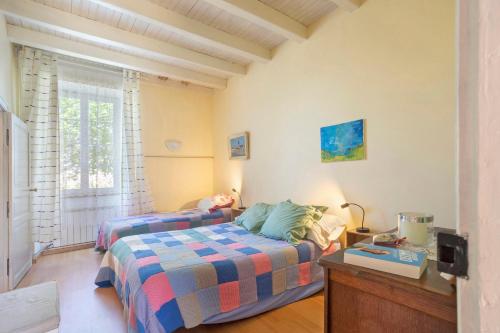 a bedroom with a bed and a table and a window at Chambres en Charente Maritime in Loiré-sur-Nie