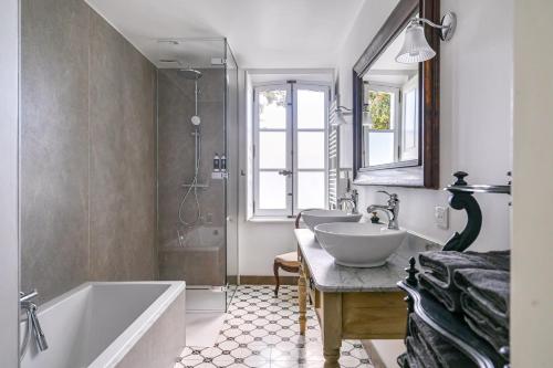 a bathroom with two sinks and a tub and a shower at Château De Jouques in Gémenos