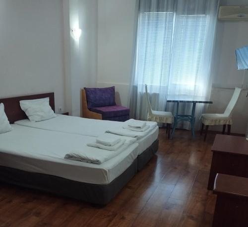 a bedroom with a bed and a table and chairs at ХОТЕЛ РАДНЕВО in Radnevo