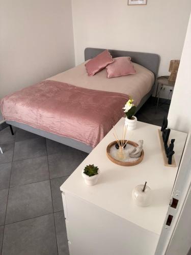 a bedroom with a bed and a white table at Douce escale lumineuse à Nancy in Nancy
