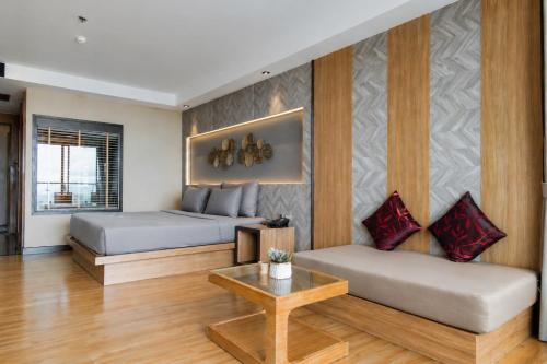 a room with two beds and a couch and a table at The Senses Resort & Pool Villas, PHUKET in Patong Beach