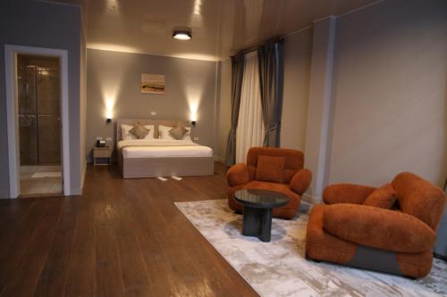 a bedroom with a bed and two chairs and a table at Haile Hotel Debre Birhan in Debre Birhan