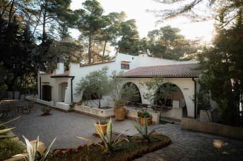 a white house with a courtyard with a patio at Villa Elefante in Isole Tremiti