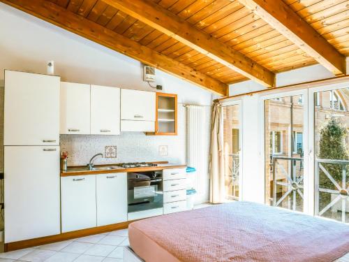 eine Küche mit weißen Schränken und einem großen Fenster in der Unterkunft Living 68 in Forlì