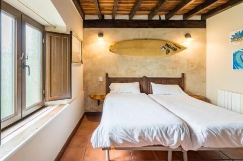 a bedroom with a bed and a window at Casa Del Surf Somo in Somo
