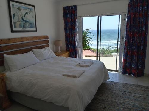 a bedroom with a bed with a view of the ocean at Galene Guest House in Port Shepstone