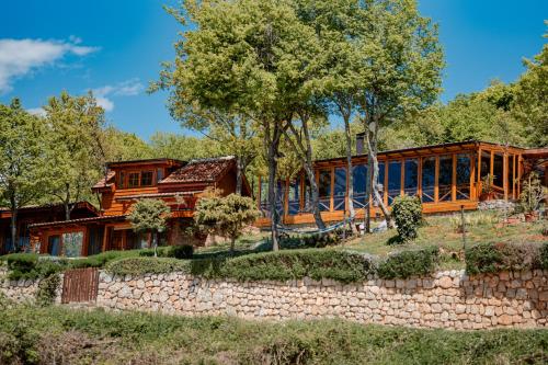 a large wooden house with a stone wall at Paradise Nest in Ohrid