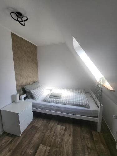 a white bed in a room with a ceiling at Gemütliche Wohnung mit großer Dachterrasse in Röhrsen