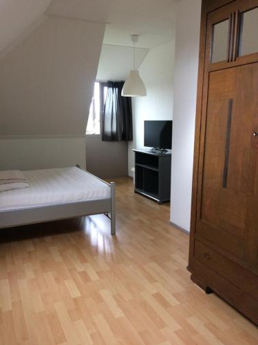 a bedroom with a bed and a wooden floor at B&B op Wijngoed Havelte in Havelte