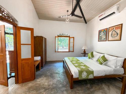 a bedroom with a bed and a window at The Surveyor's Bungalow in Udugampola