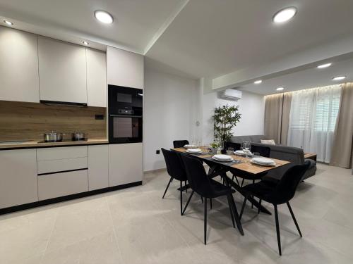 a dining room and kitchen with a table and chairs at Holiday Home Nada in Tučepi