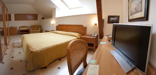 a bedroom with a bed and a flat screen tv at Villa Angelina in Massa Lubrense