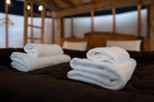two stacks of towels on top of a bed at The Yurts at Margo's Garden, Kiroro in Shiribeshi