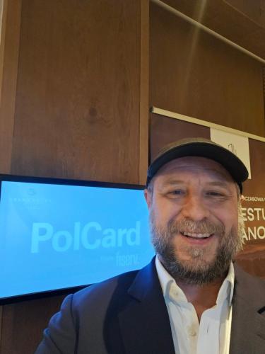 a man is wearing a hat and smiling at Michal in Tleń