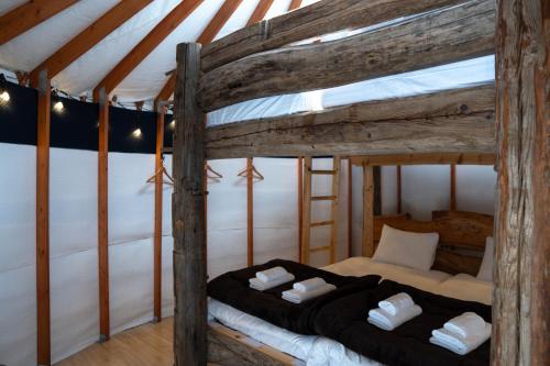 two beds in a room with wooden beams at The Yurts at Margo's Garden, Kiroro in Shiribeshi