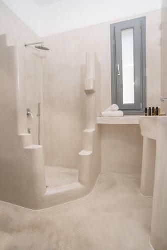 a white bathroom with a sink and a mirror at Lagadi Suites Mesaria in Mesaria