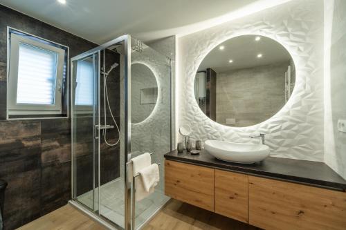 a bathroom with a sink and a mirror at Apartments Barbara Kraljevica in Kraljevica