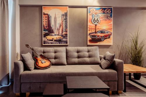 a living room with a couch and a guitar at Old Cinema Suites - Stylishly Decorated Retreat with Pool or Jacuzzi by the Sea in the Heart of Laganas Βy Villa Mana Gers in Laganas