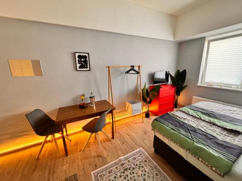 a bedroom with a bed and a desk and a table at Fuchsbau Komfort Zimmer in Nordhausen