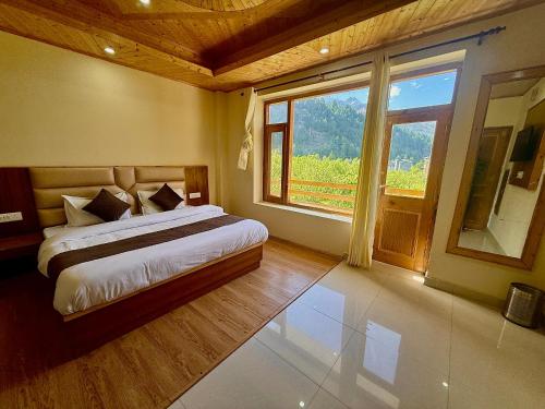 a bedroom with a bed and a large window at The Cow Boy Manali in Manāli