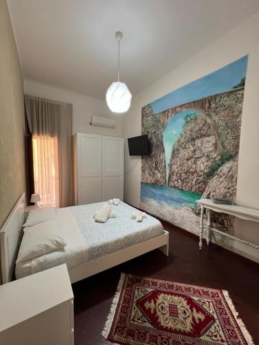 a bedroom with a bed and a painting on the wall at B&b I 7 MARI in Salerno