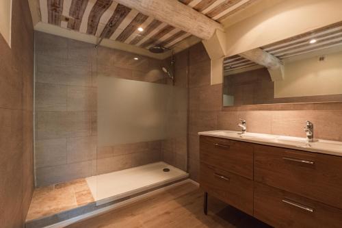 a bathroom with a sink and a bath tub at Hôtel Le Rocher des Abeilles in Saint-Martin-de-Castillon
