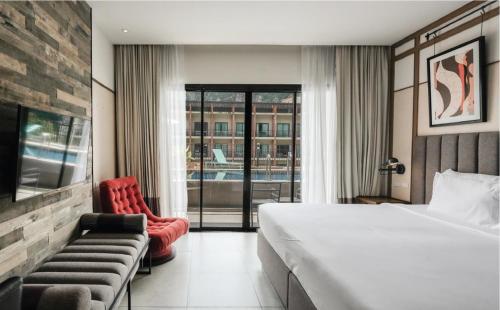 a hotel room with a bed and a red chair at Sugar Marina Hotel CLIFFHANGER Aonang in Ao Nang Beach