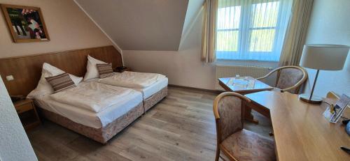 ein kleines Schlafzimmer mit einem Bett und einem Tisch in der Unterkunft Hotel Mecklenburger Mühle Garni in Wismar