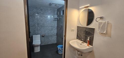 a bathroom with a sink and a shower with a mirror at Johny's Villa, Homestay, Wayanad in Pulpally