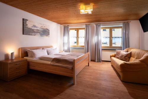 a bedroom with a bed and a couch at Bayerische Gastwirtschaft Dimpfl-Stadl in Lam
