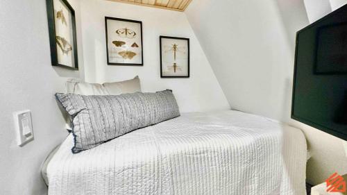 a white bed with a pillow in a room at Serene Mountain Waterfront A-Frame Cabin in Robbinsville