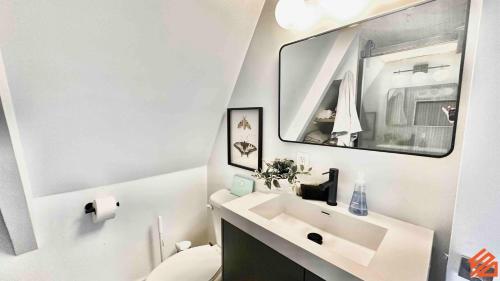 a white bathroom with a sink and a mirror at Serene Mountain Waterfront A-Frame Cabin in Robbinsville