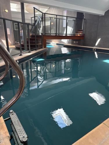 a swimming pool with blue water in a building at Kyriad Hotel Dijon Centre Gare in Dijon