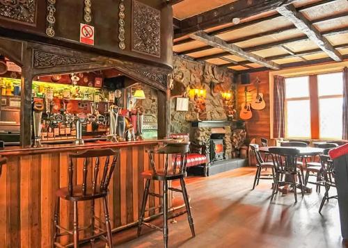 a bar in a pub with tables and chairs at Ardlui Holiday Park in Arrochar