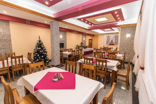a dining room with tables and a christmas tree at Dom Wczasowy Na Szczycie in Zakopane