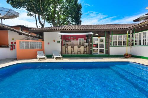 a swimming pool in front of a house at Pérola da Mata in Boicucanga