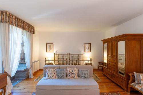 a living room with a bed and a dresser at Feel Discovery Casa de Vilarinho de São Romão in Sabrosa