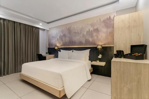 a bedroom with a white bed and a painting on the wall at Country Inn Smart Stays, Rishikesh at Tapovan in Rishīkesh