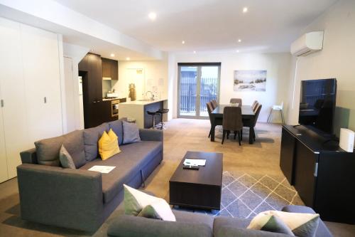 a living room with a couch and a table at Docklands Serenity in Melbourne