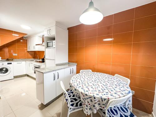 a kitchen with a table and a table and chairs at Casa das Faluchas by ALÔGA in Finisterre