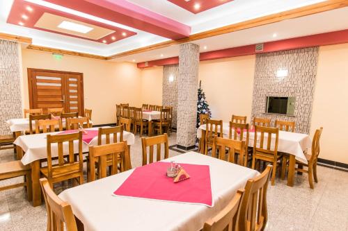 a restaurant with tables and chairs and a christmas tree at Dom Wczasowy Na Szczycie in Zakopane