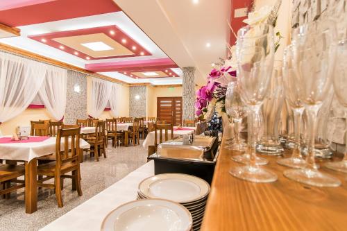 a restaurant with tables and chairs and glasses on a counter at Dom Wczasowy Na Szczycie in Zakopane