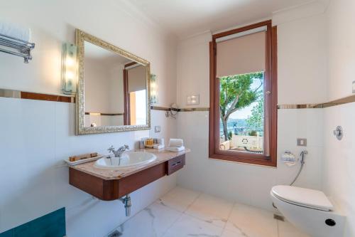 a bathroom with a sink and a toilet and a mirror at Fateh Garh Resort by Fateh Collection in Udaipur